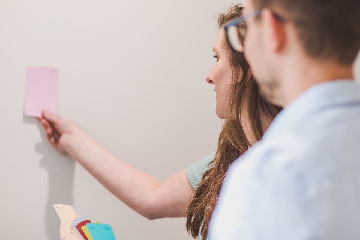 A couple deliberates on paint color selections for their home interior renovation project.