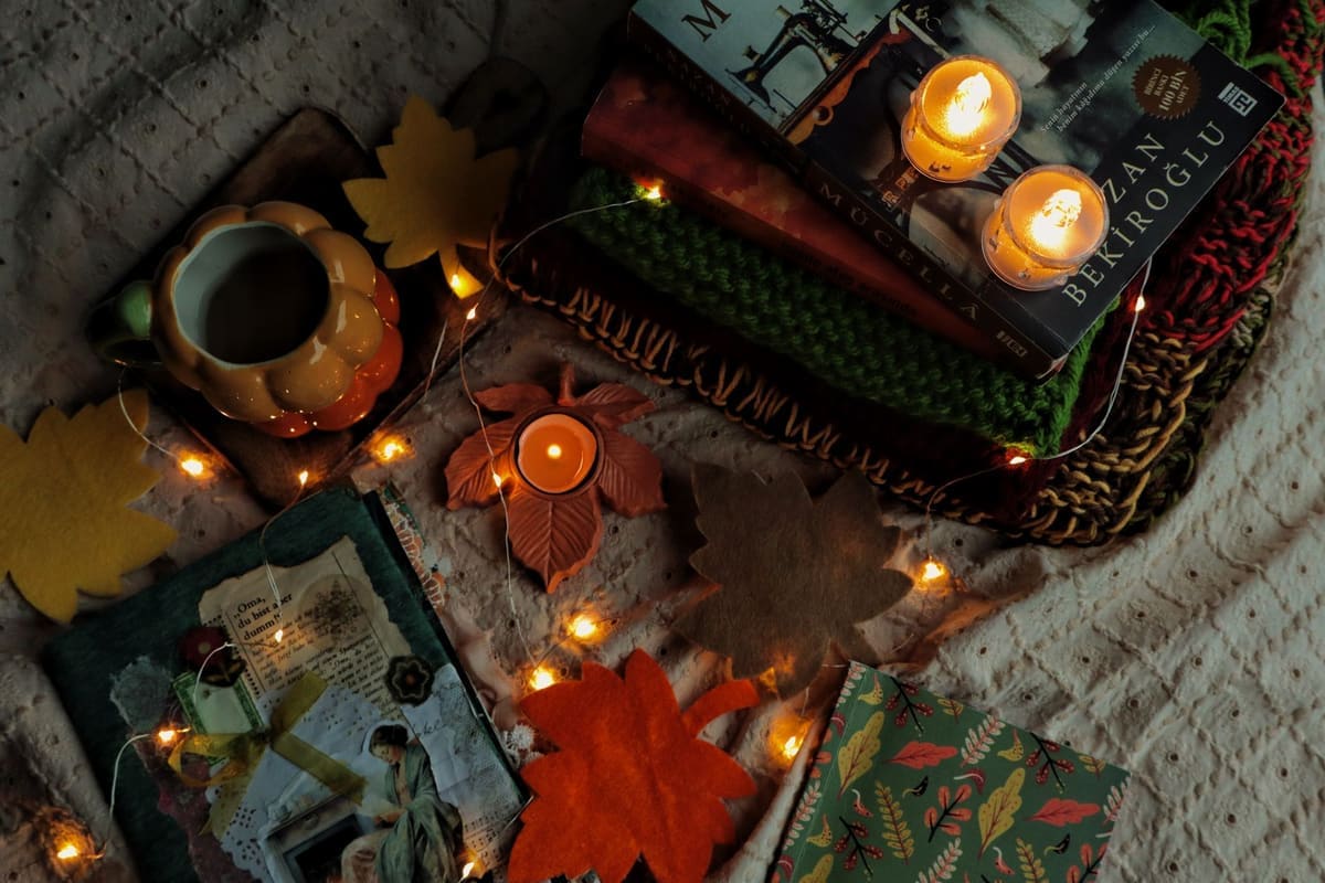 Warm autumn scene with books, candles, and cozy decorations creating a relaxing atmosphere.