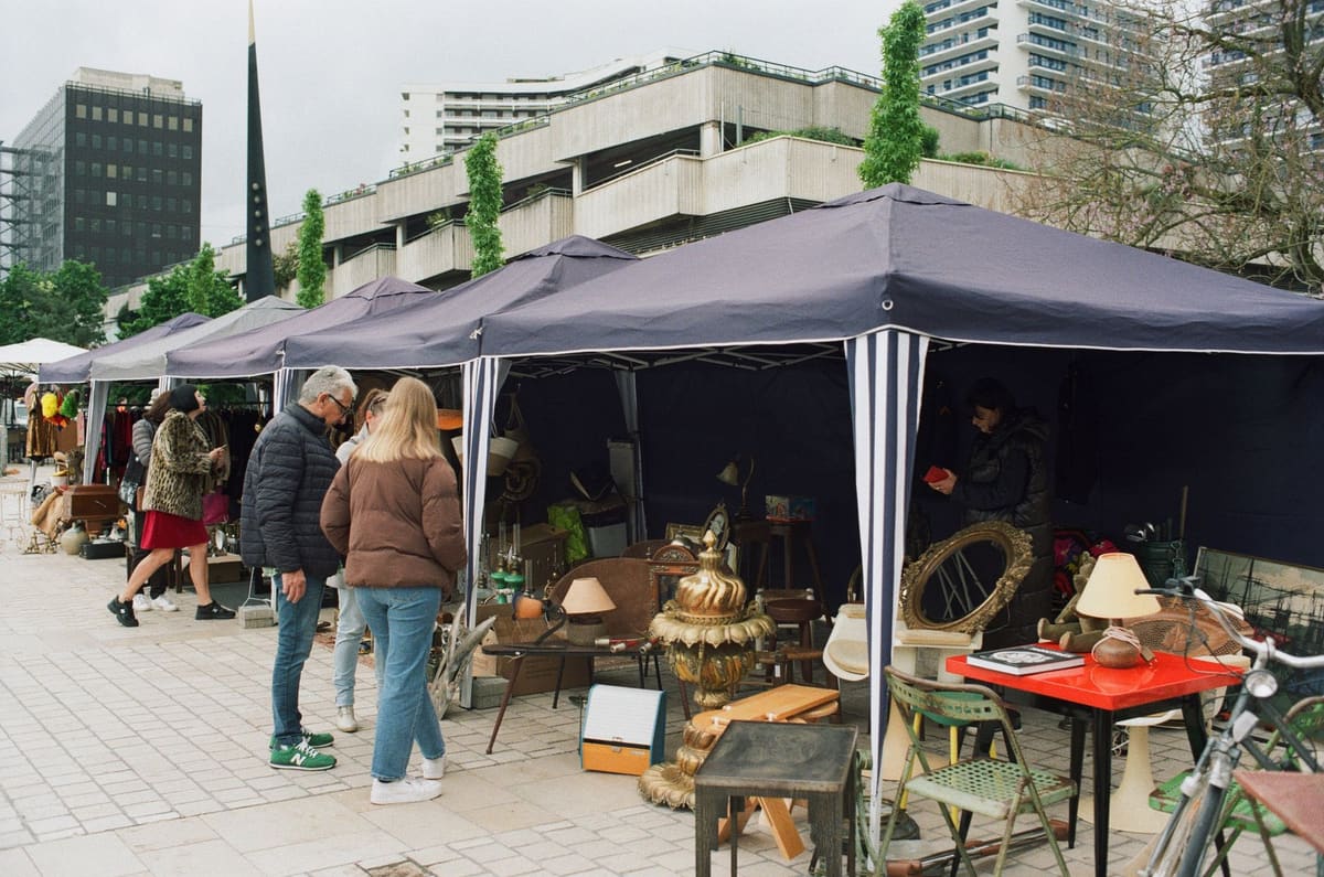 Explore vibrant market stalls in Nancy, Grand Est, France, with diverse antiques and shoppers.