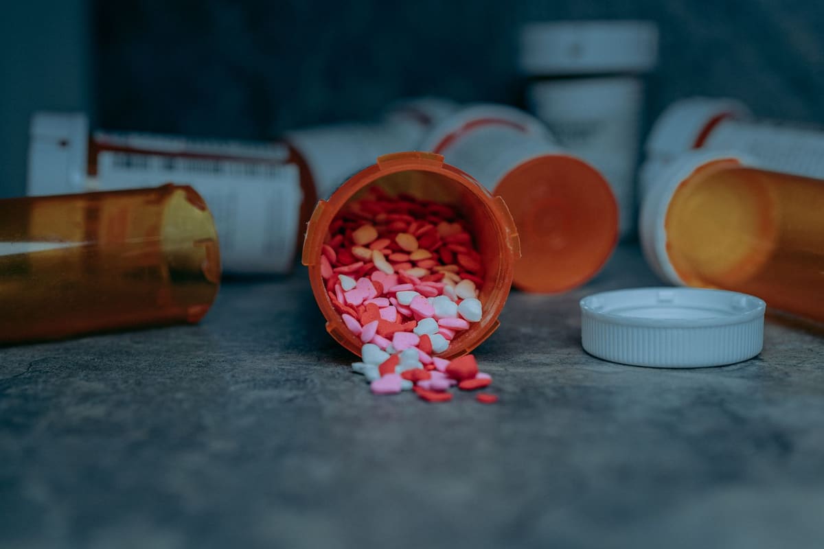 Colorful pills spilling from a prescription bottle on a counter