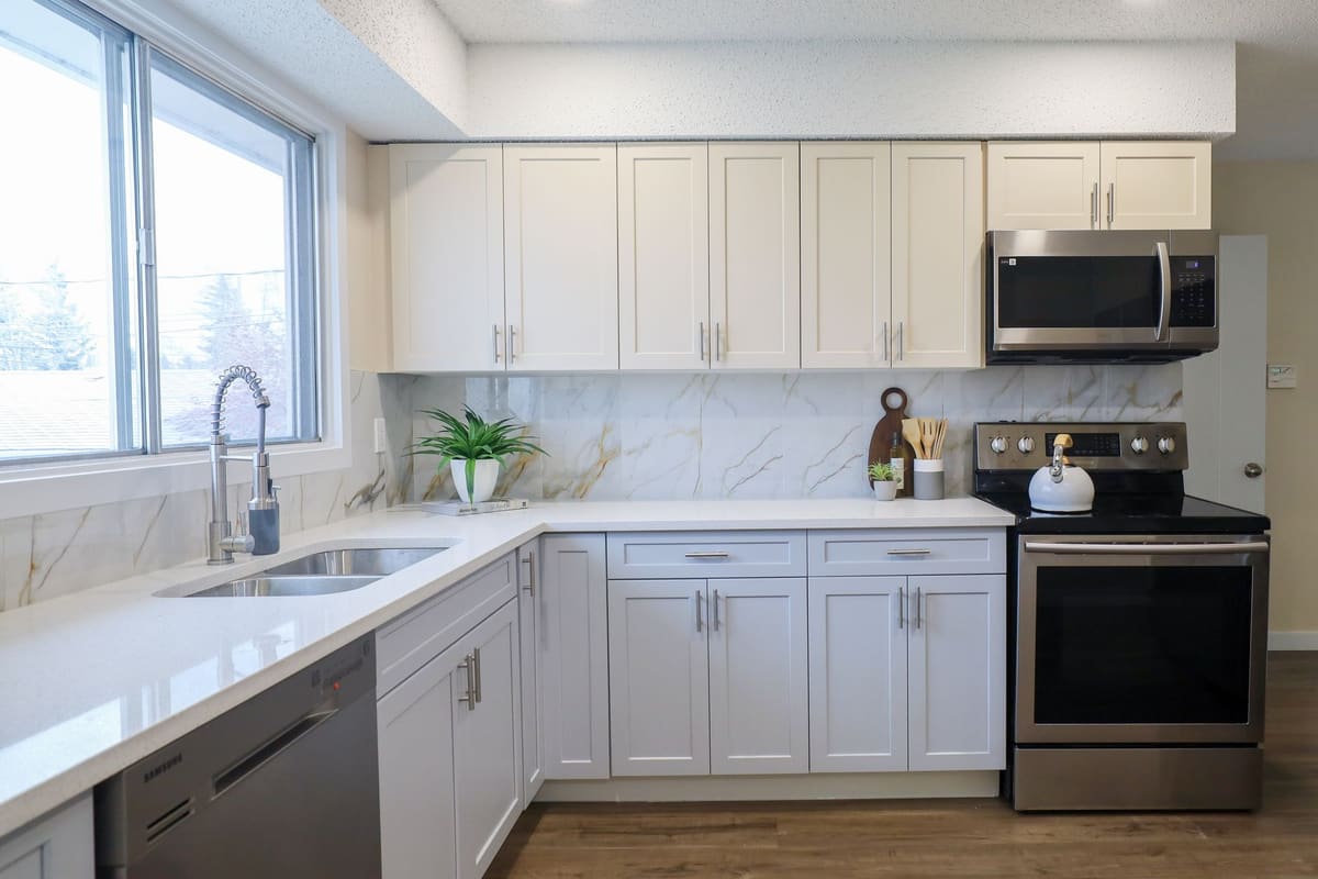 A contemporary kitchen with sleek cabinetry and stainless steel appliances, featuring ample natural light.