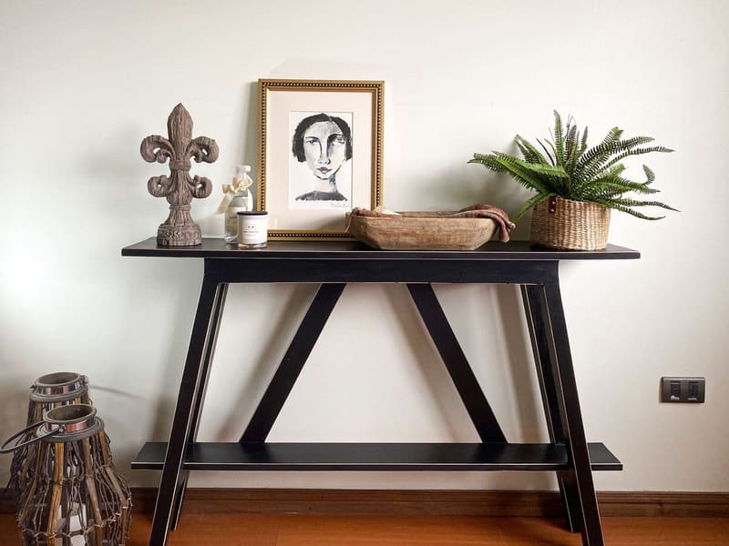 Elegant black console table with decorative items, perfect for modern interiors.
