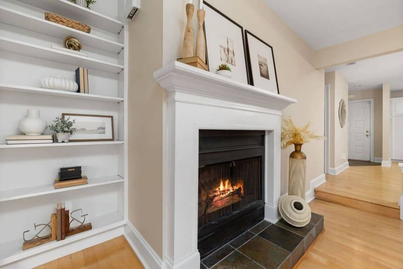 Elegant living room interior featuring a lit fireplace and decorative shelving.